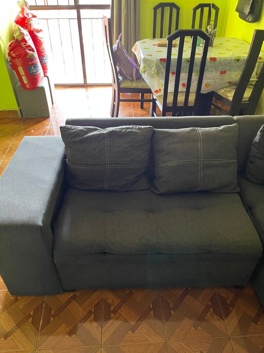 Sofá gris de tela limpio tras el servicio a domicilio
